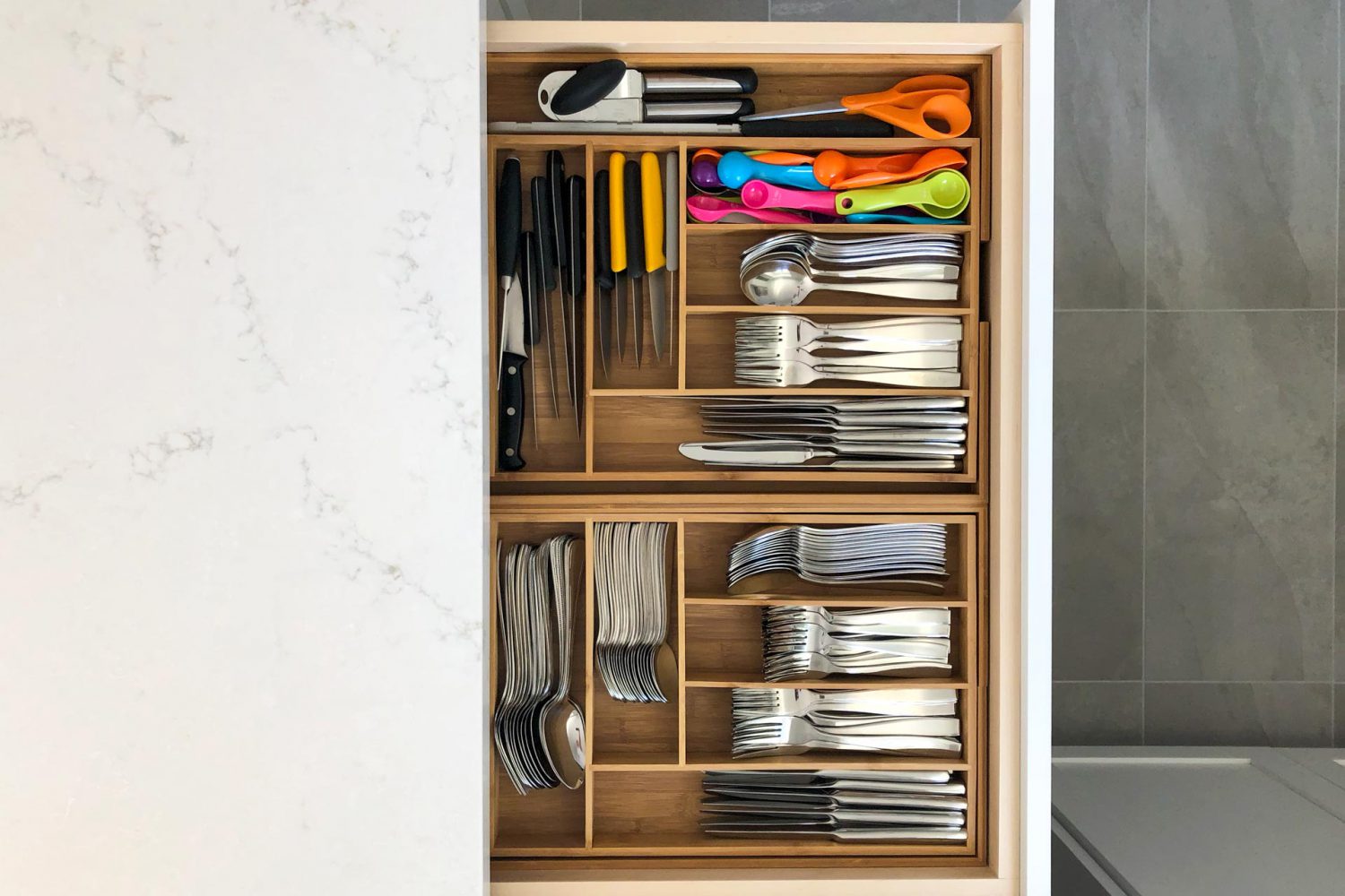 a kitchen drawer is pulled out showing its contents